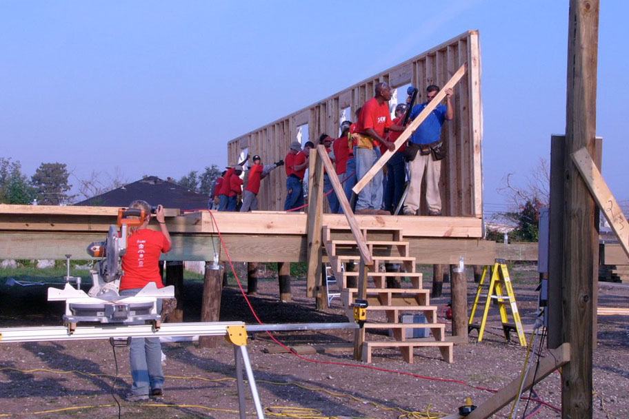 Workers stand up a wall during home construction