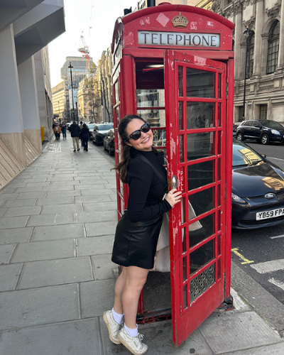 Avery Watts climbs into an iconic red phonebooth in England