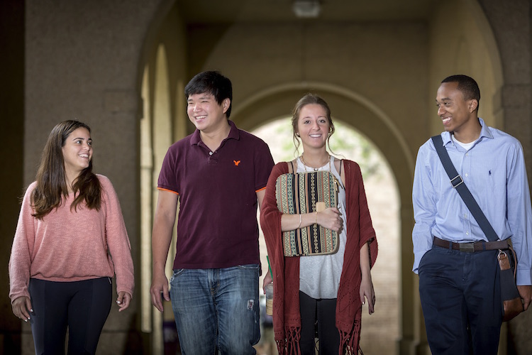 students walking under colonnade