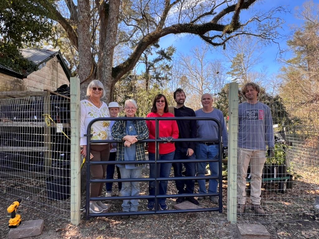 volunteers standing behind newly installed gate